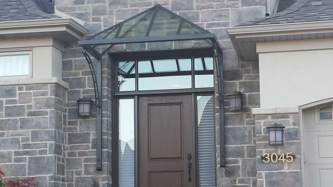 Abri de porte en métal et verre